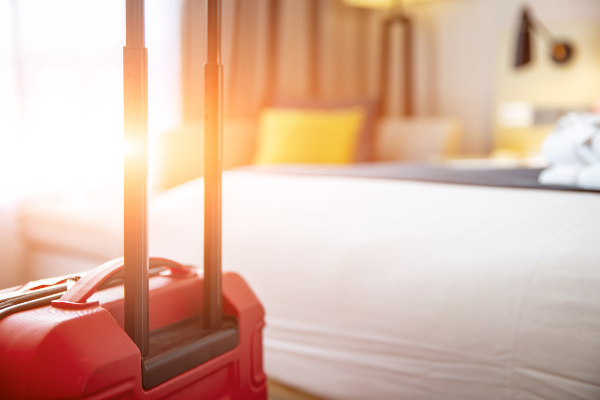 Image of a suitcase near a hotel bed