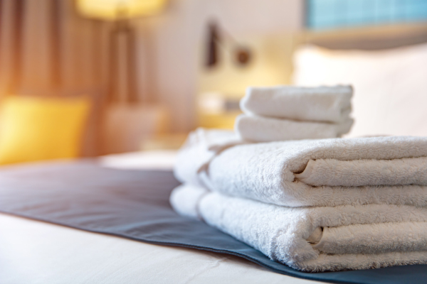 Image of a stack of towels on a hotel bed