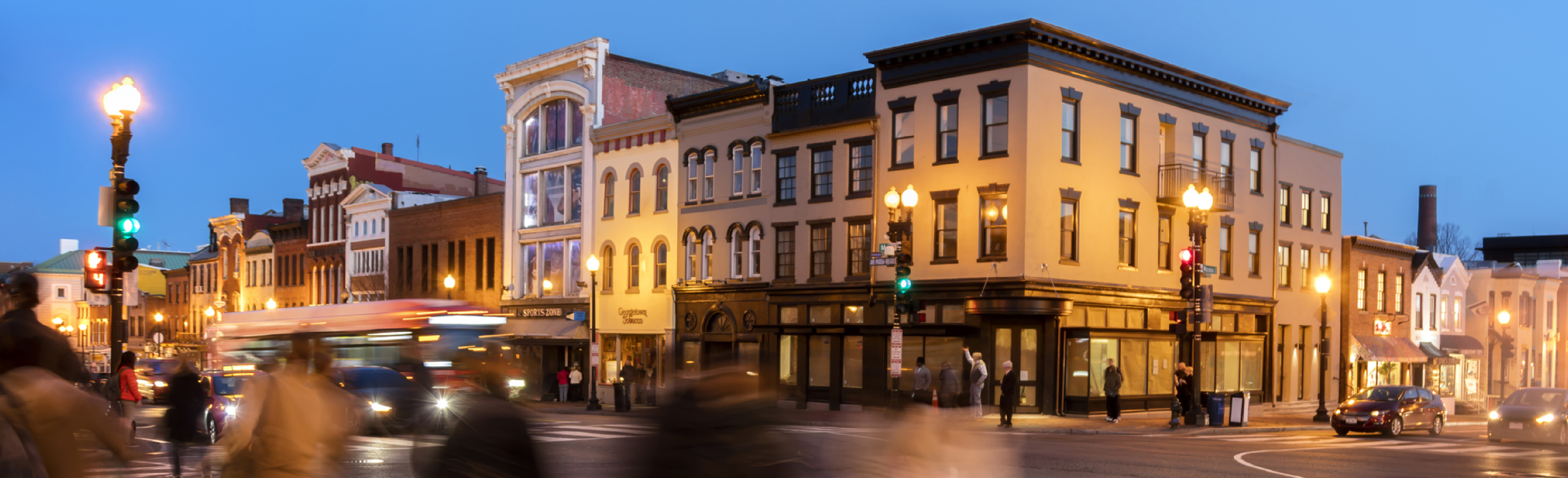 Motion blurred pedestrians crossing street at dusk in Georgetown, Washington District of Columbia